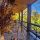 North Georgia fall getaway - Wooden porch with a trough of orange pumpkins and dried grasses, set against autumn foliage and a blue sky.
