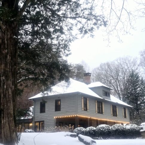 Beechwood Inn surrounded by snow-covered trees and a snowy lawn