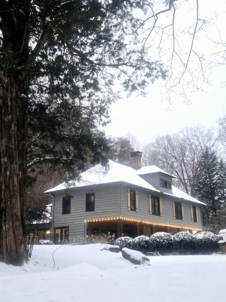 Beechwood Inn surrounded by snow-covered trees and a snowy lawn