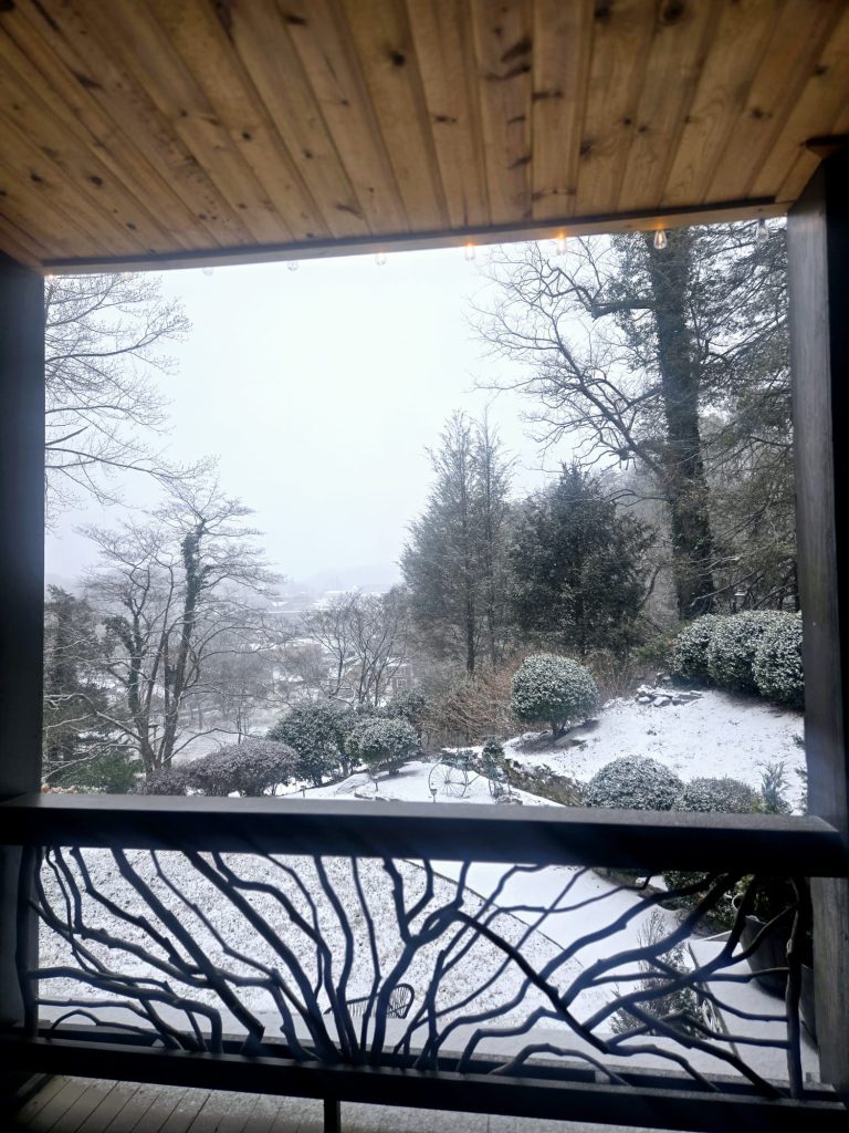 View from the Beechwood Inn porch across snow-covered gardens and trees