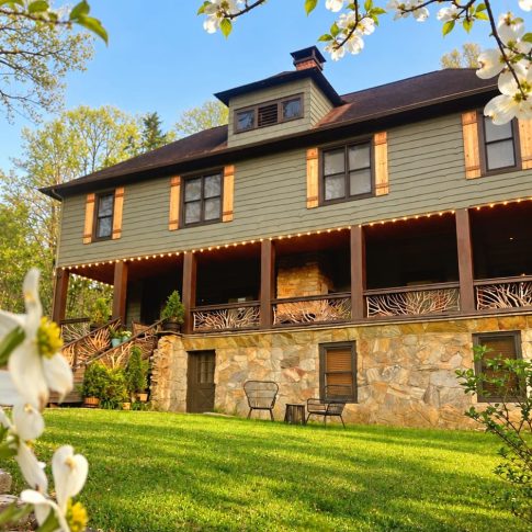 Beechwood Inn farmhouse and green lawn framed by spring blossoms