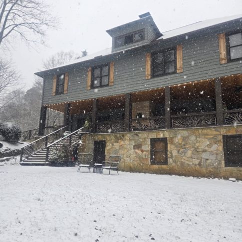 Snow falling around the historic Beechwood Inn farmhouse and front lawn